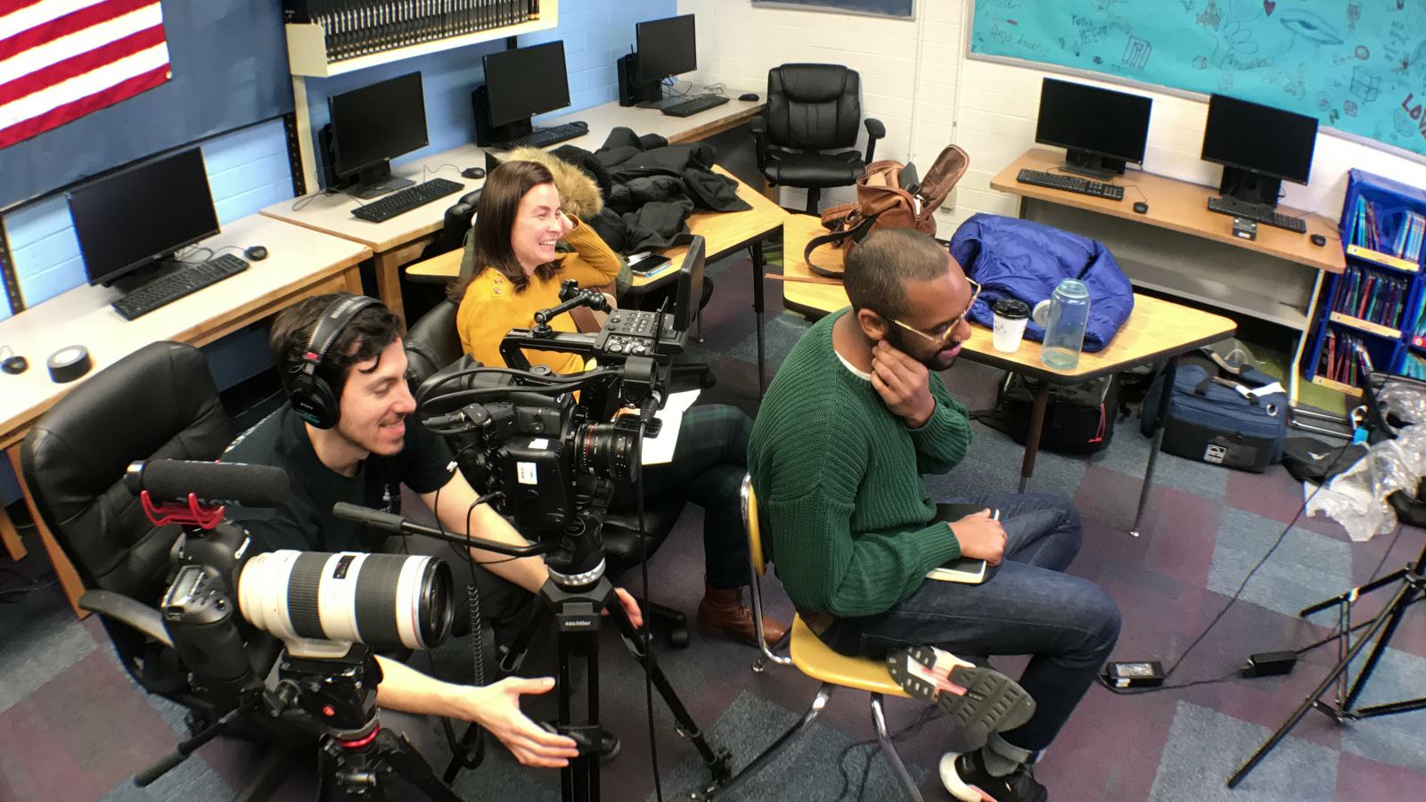 Overhead view of a documentary camera crew and interview equipment in a computer classroom