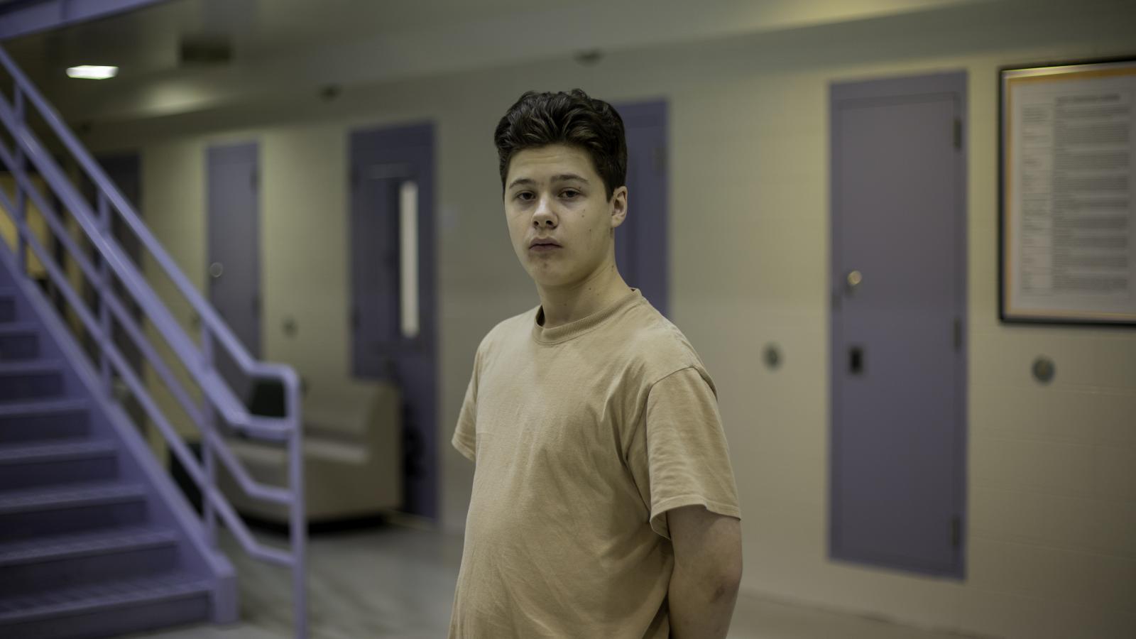 Teenager standing alone in juvenile facility