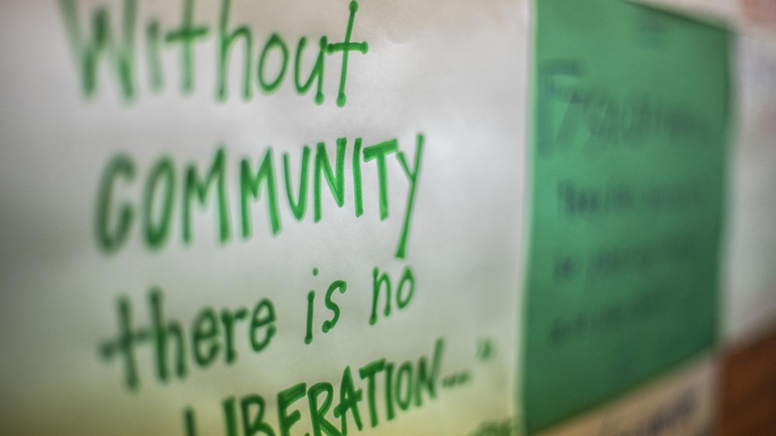 Handwritten inspirational community sign featuring a quote by Audre Lorde, "Without community there is no liberation"