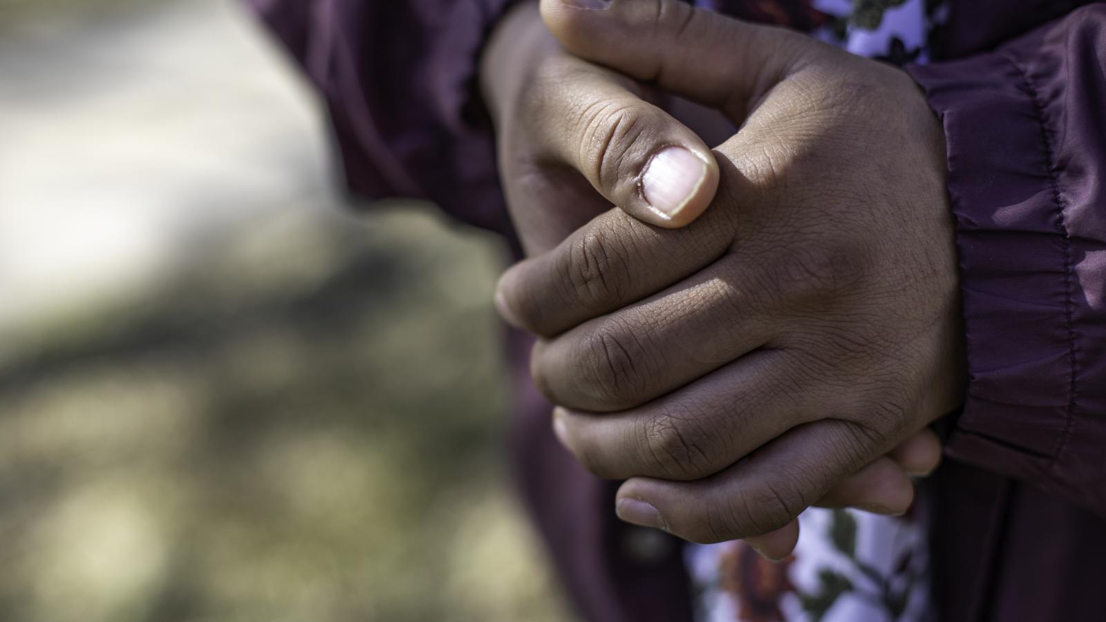 A young person's clasped hands