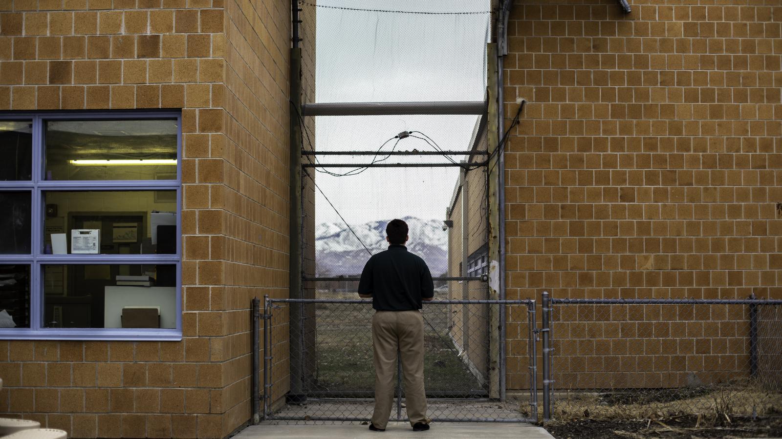 Teenager outside of juvenile facility, looking into the distance